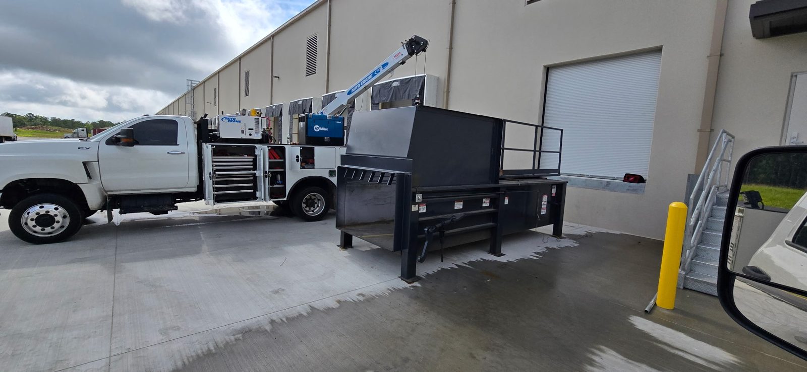 SHD service truck with crane and welder beside a compactor unit